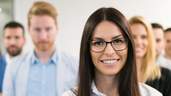 Frau im Vordergrund, Kollegen im Hintergrund, © Shutterstock Frau im Vordergrund, Kollegen im Hintergrund, © Shutterstock