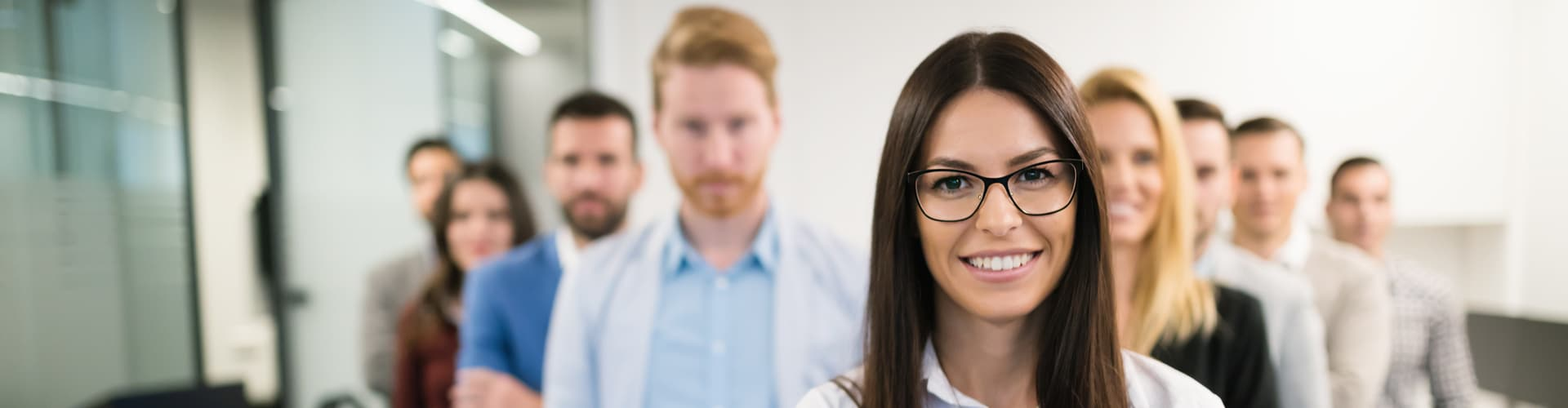 Frau im Vordergrund, Kollegen im Hintergrund, © Shutterstock