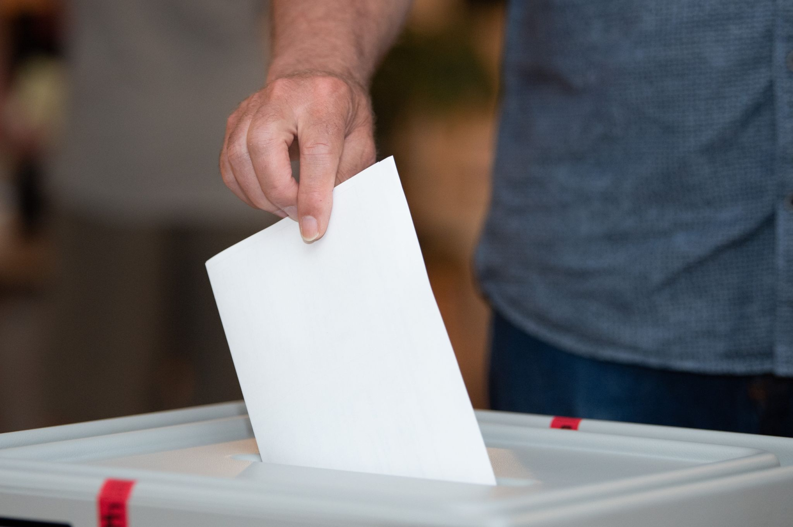 Ein Wähler wirft in einem Wahllokal seinen Stimmzettel in die Wahlurne.