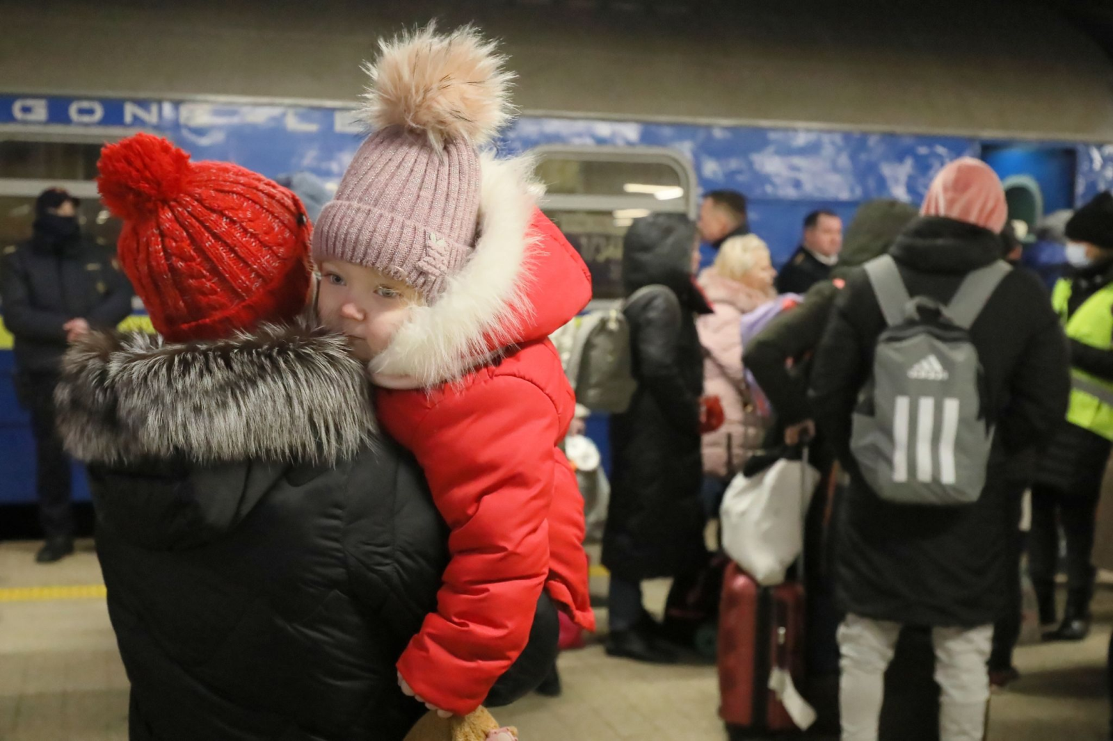 Ukrainische Flüchtlinge kommen mit einem ukrainischen Personenzug an einem Bahnhof an.