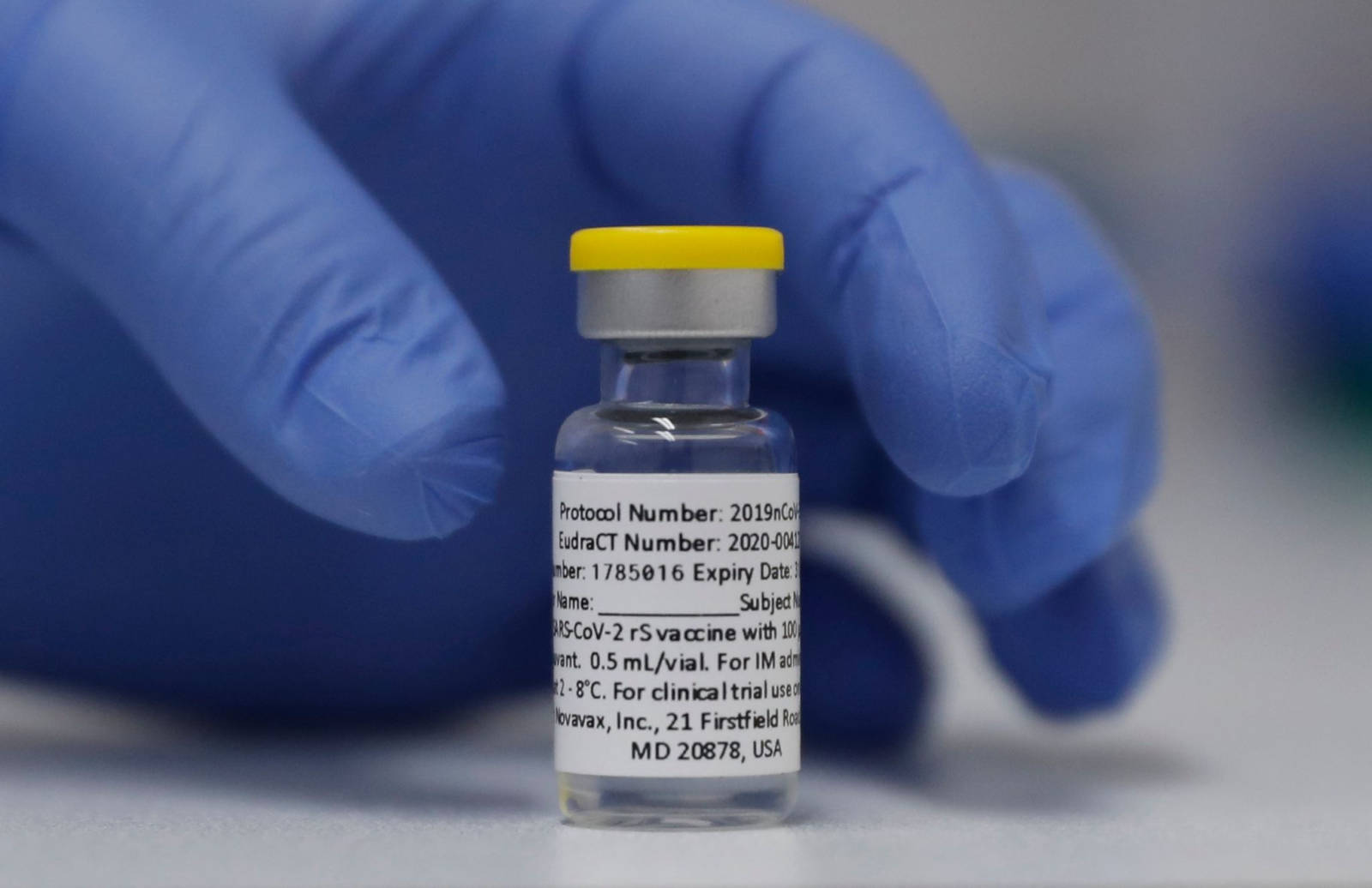 Eine Ampulle mit dem Corona-Impfstoff des US-Herstellers Novavax steht auf einem Tisch.