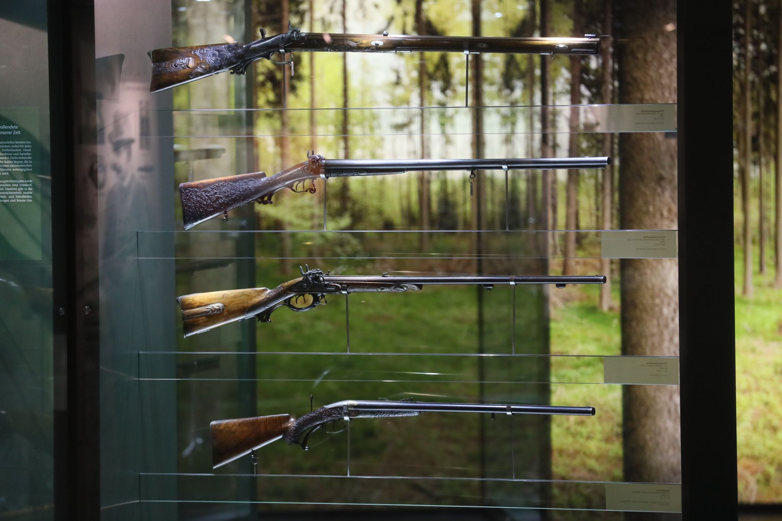 Gewehre hängen in einer Vitrine im Waffenmuseum.