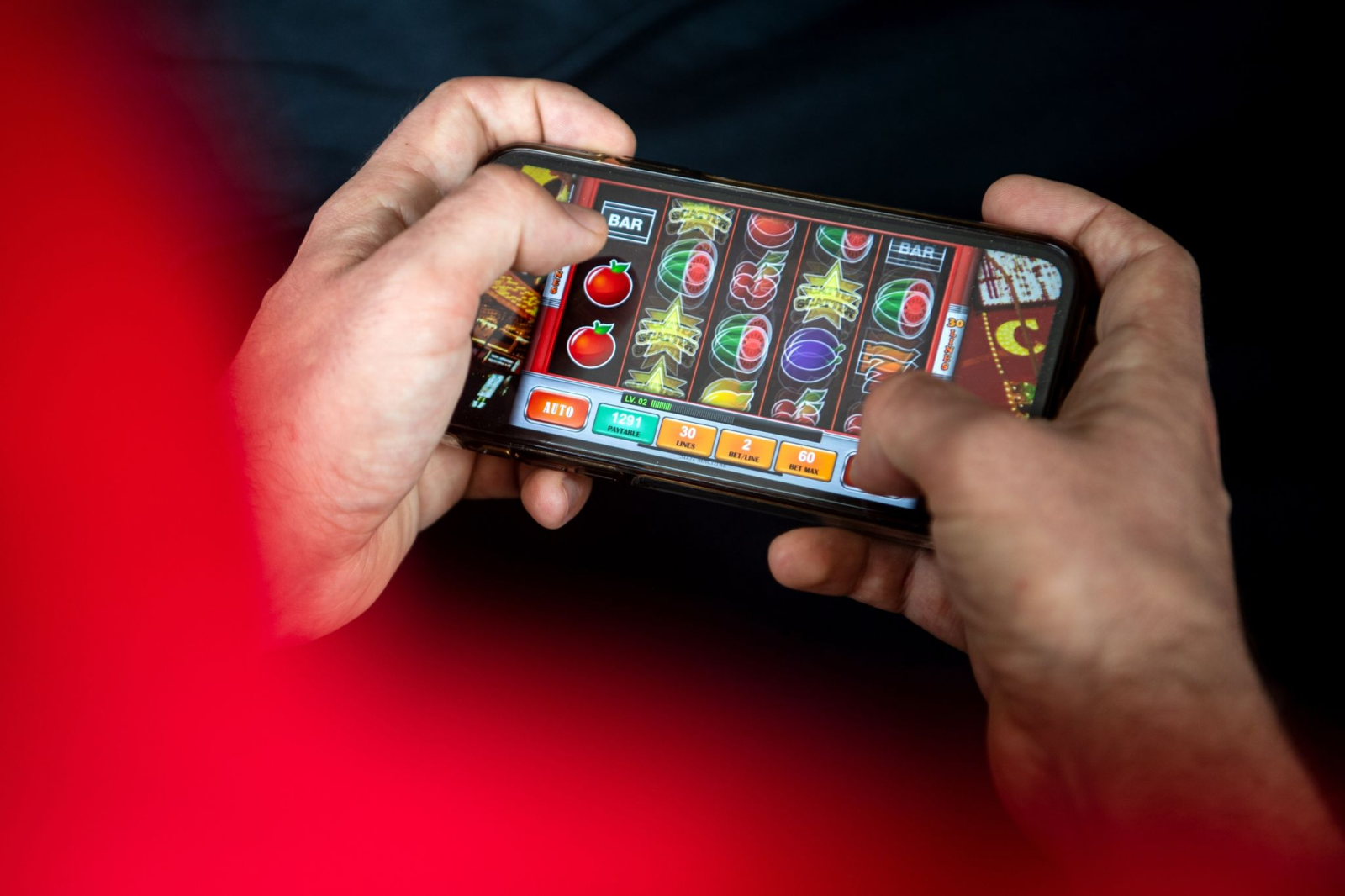 Auf einem Smartphone spielt ein Mann ein Online-Spiel.