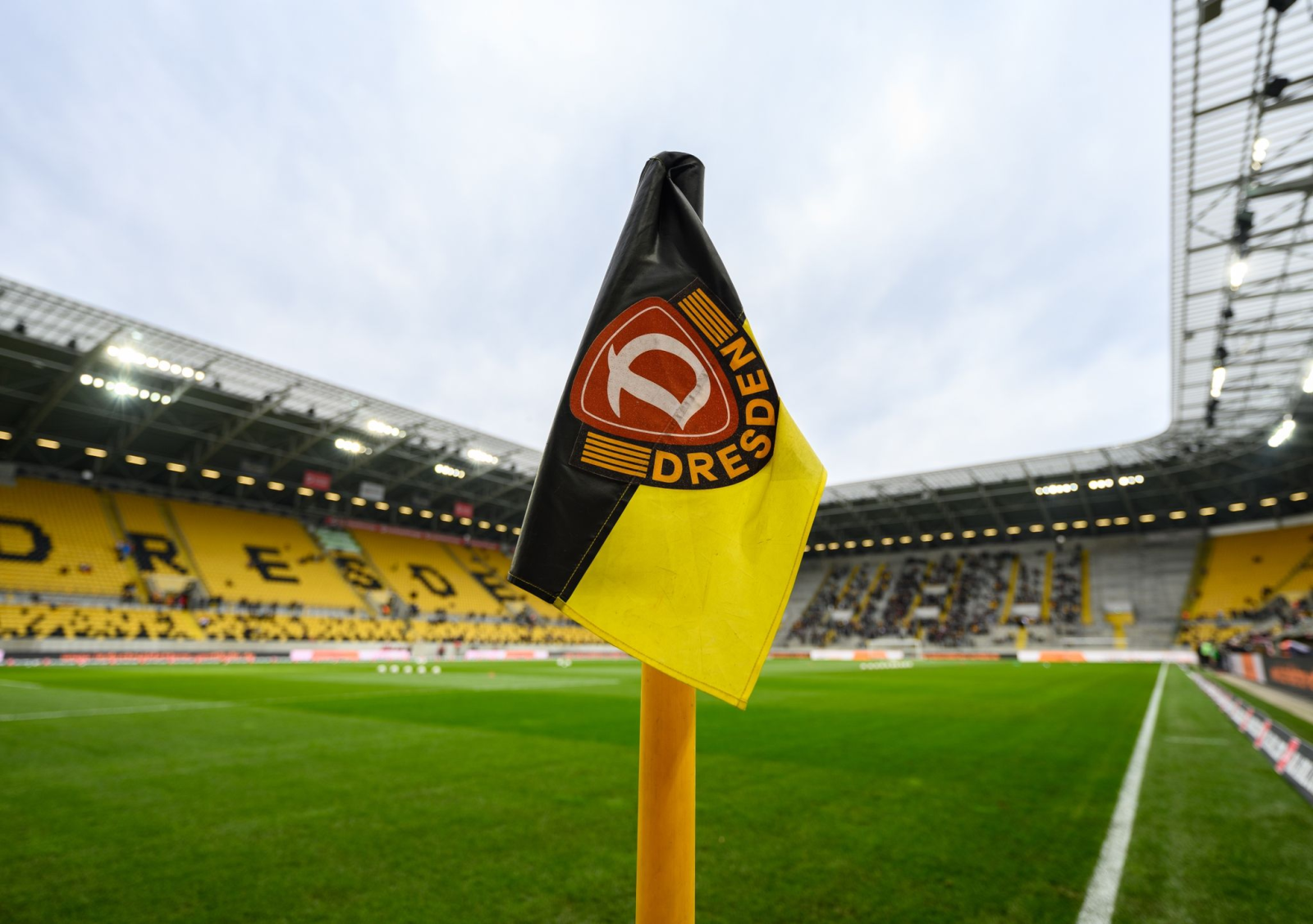 Eine Eckfahne mit dem Logo der SG Dynamo Dresden steht im Stadion an einer Ecke., © Robert Michael/dpa/Archivbild