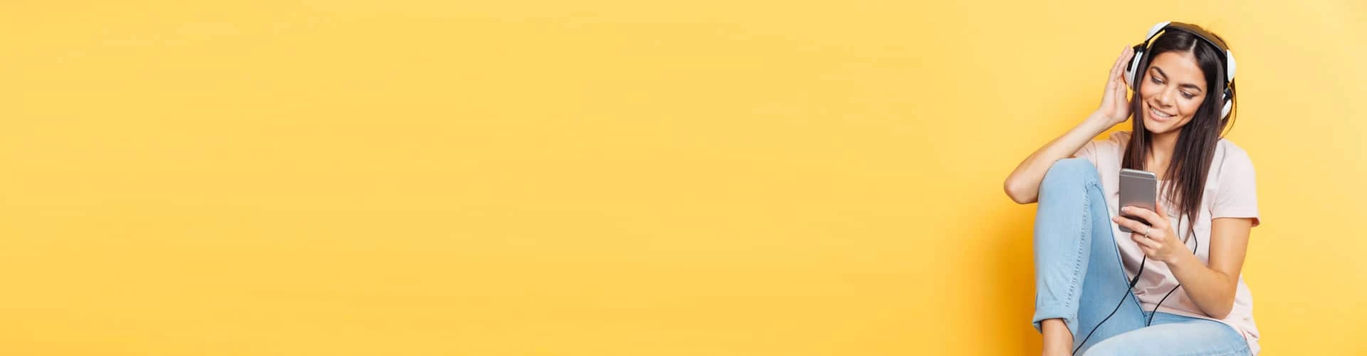 Frau hört mich Kopfhörern Musik und lächelt dabei., © Shutterstock Frau hört mich Kopfhörern Musik und lächelt dabei., © Shutterstock