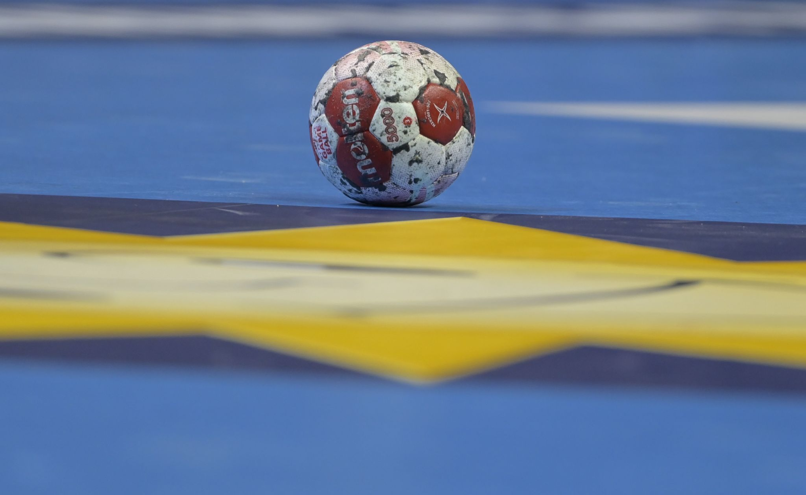 Ein Spielball liegt auf einem Handballfeld.