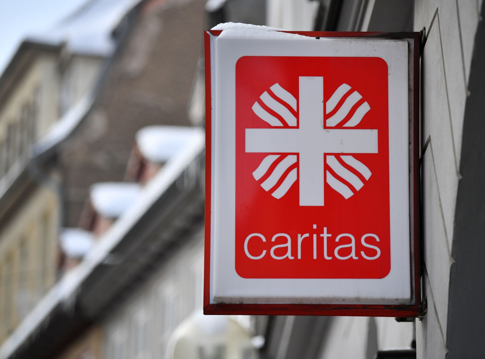 Ein Schild hängt an einer Regionalstelle der Caritas.