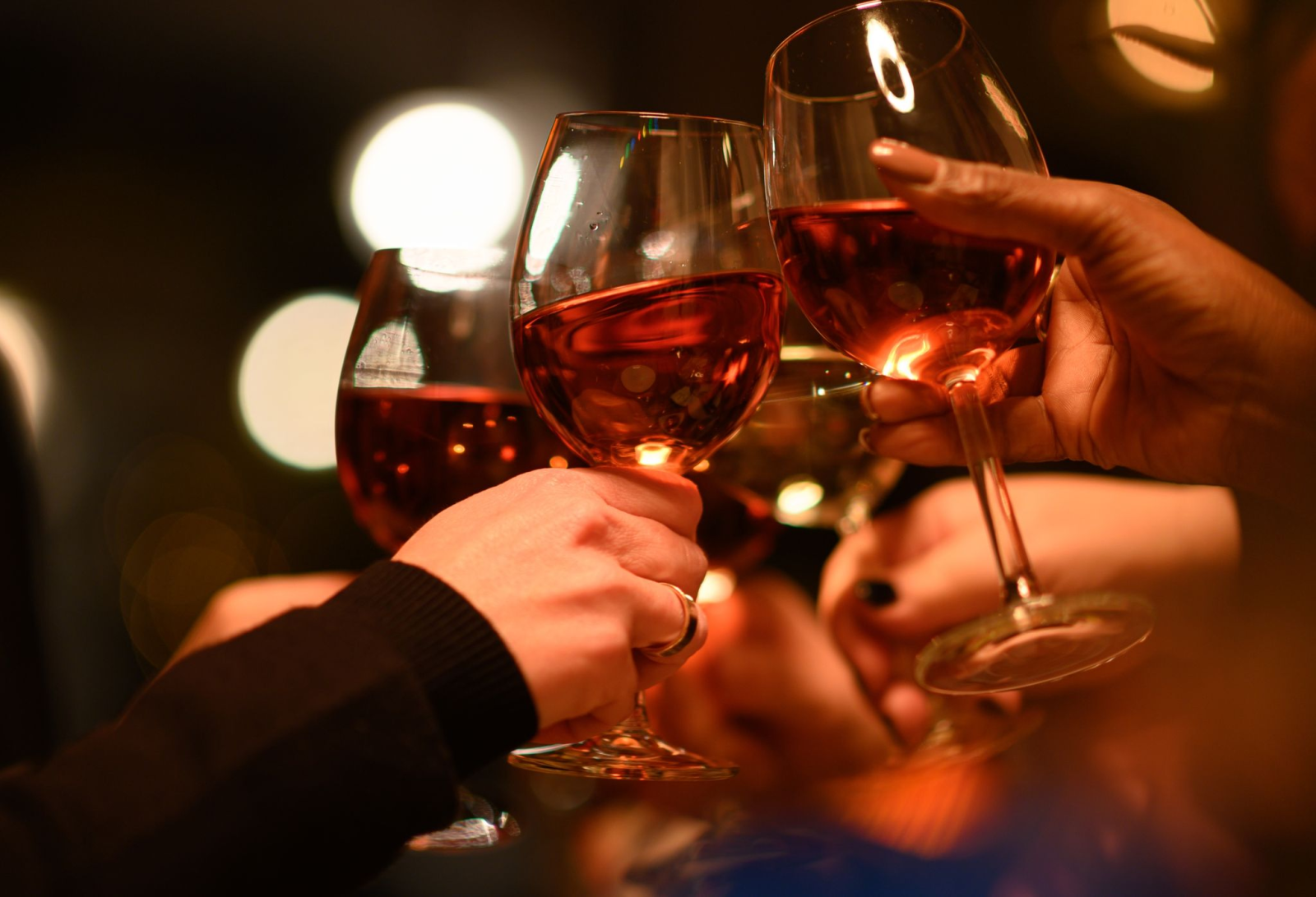 Gäste stoßen in einem Restaurant mit ihren Weingläsern an.