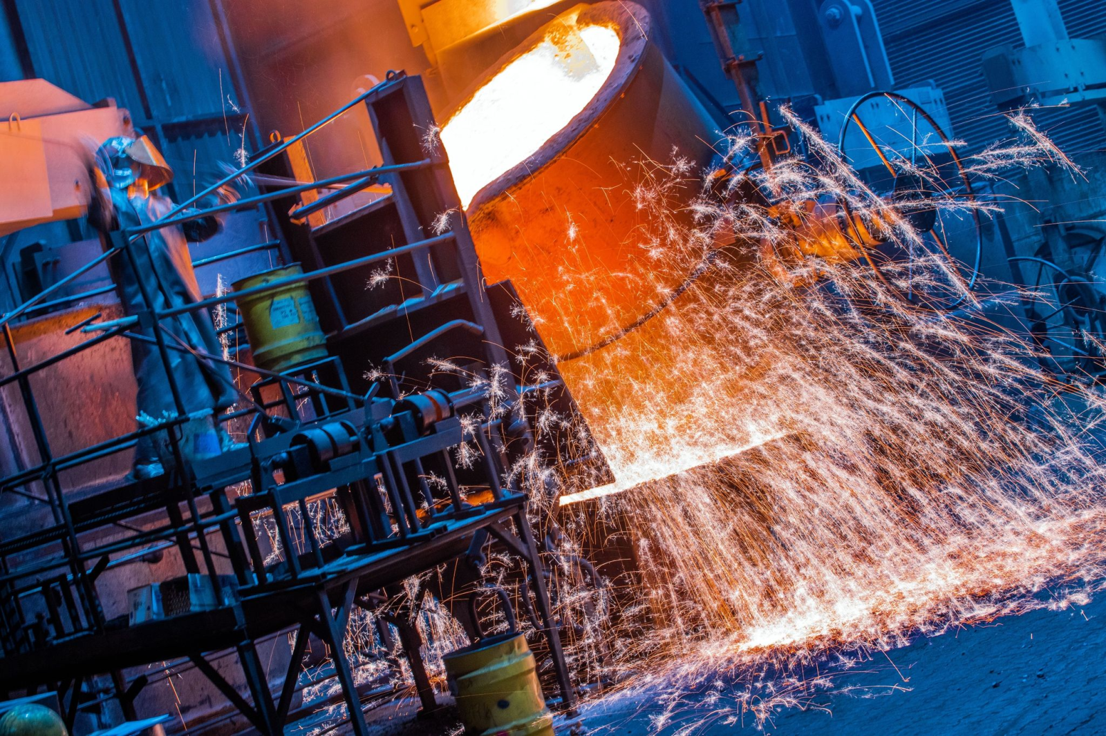 Die Temperatur von flüssigem Eisen wird von Arbeitern in einer Eisengießerei vor der Weiterverarbeitung kontrolliert.
