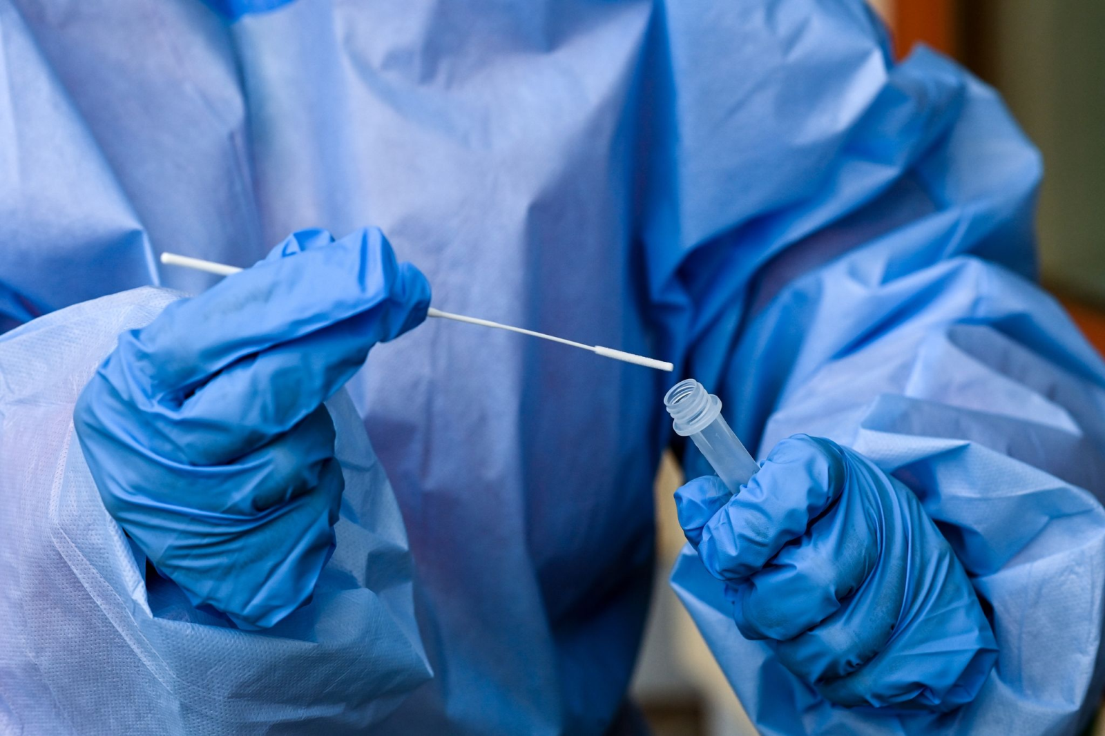 Eine Krankenschwester steckt ein Abstrichstäbchen in die Flüssigkeit eines Corona-Schnelltests., © Jens Kalaene/dpa-Zentralbild/dpa/Symbolbild