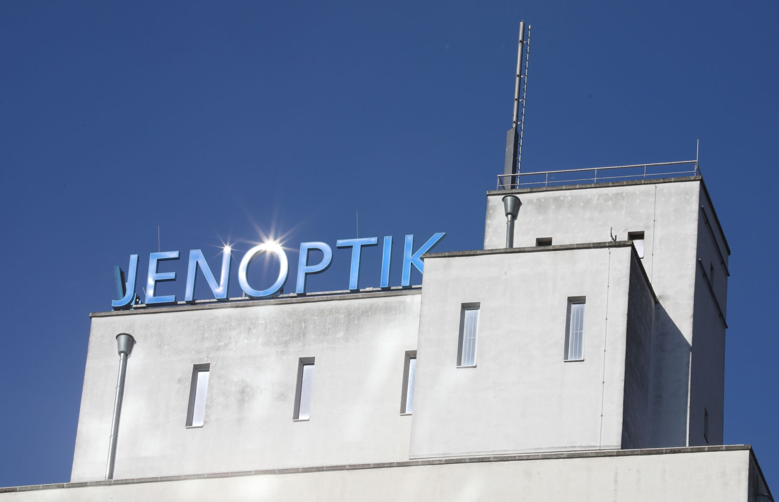 Die Sonne spiegelt sich im Schriftzug «Jenoptik» auf dem Dach des Verwaltungsgebäudes der Jenoptik AG.