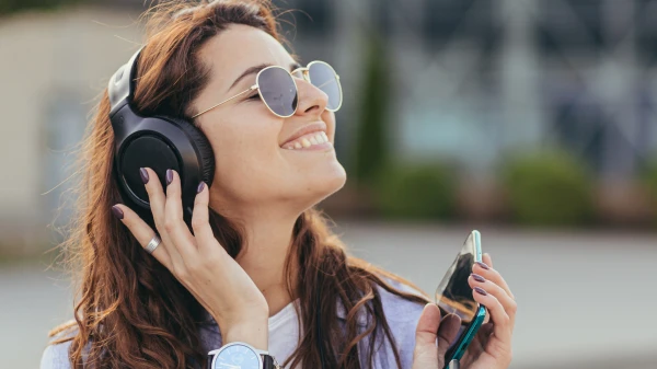 Frau mit Kopfhörern in der Stadt, © Shutterstock Frau mit Kopfhörern in der Stadt, © Shutterstock