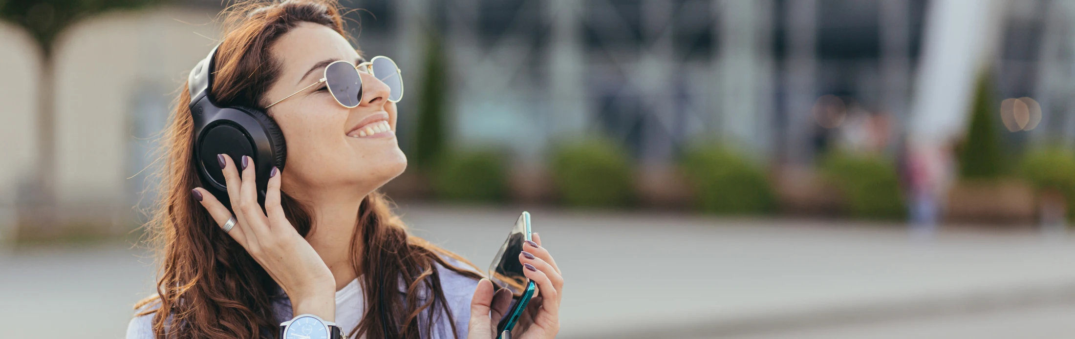 Frau mit Kopfhörern in der Stadt, © Shutterstock Frau mit Kopfhörern in der Stadt, © Shutterstock