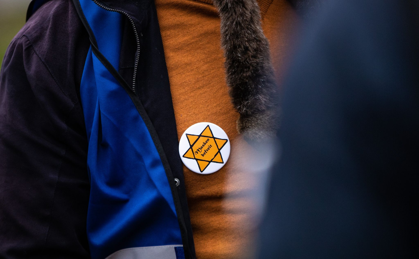 Ein Teilnehmer einer Kundgebung trägt einen symbolischen Judenstern auf seiner Brust.