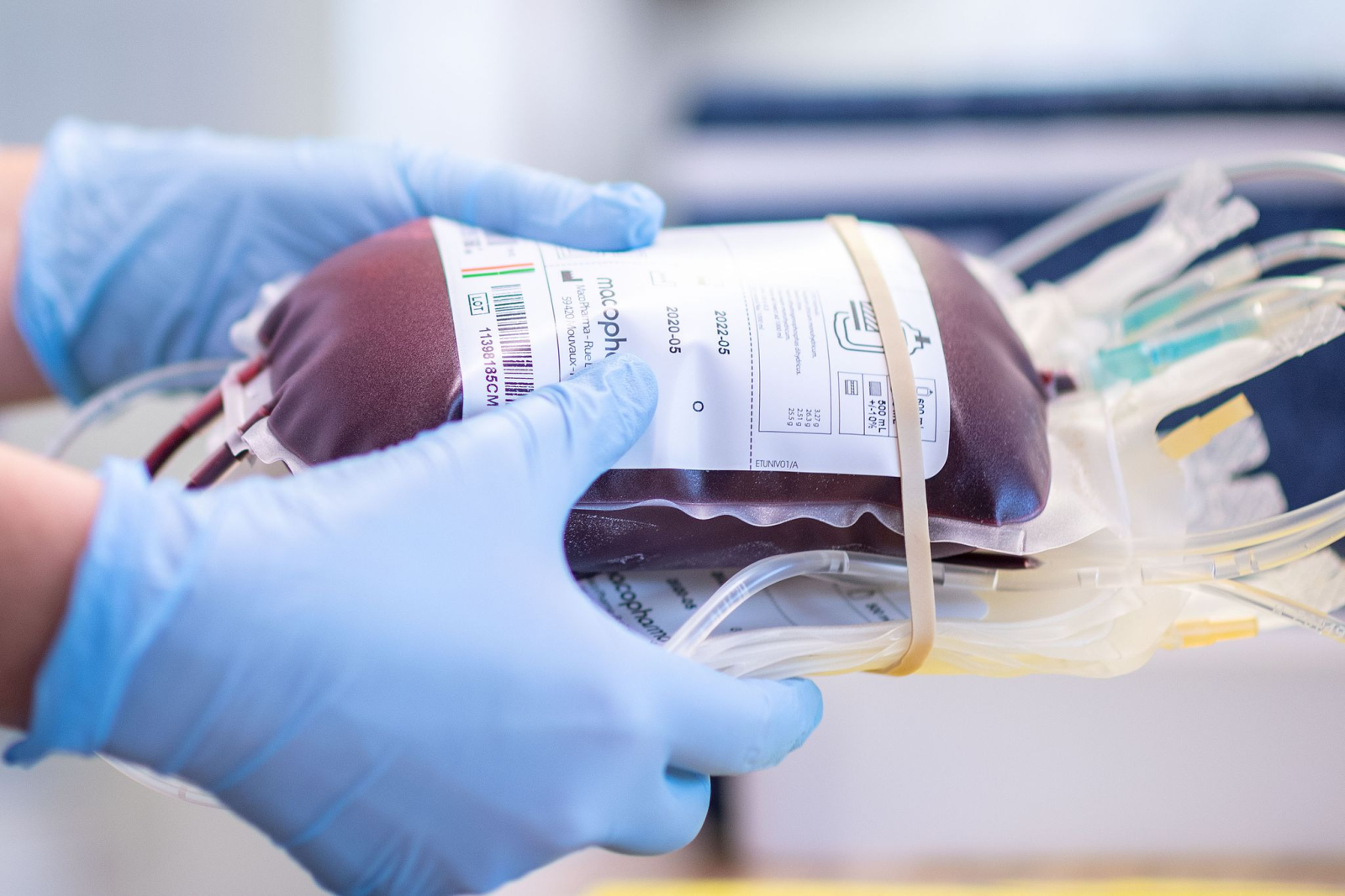 Eine Mitarbeiterin eines Blutspendezentrums hält eine Blutkonserve in den Händen.