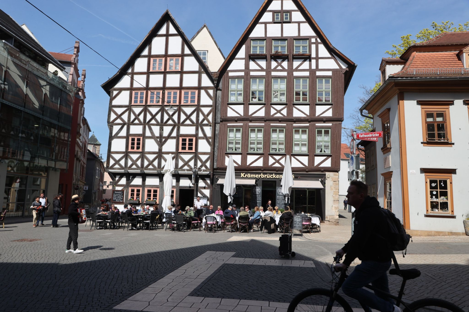 Gäste sitzen vor Restaurants und Cafes im Zentrum von Erfurt.