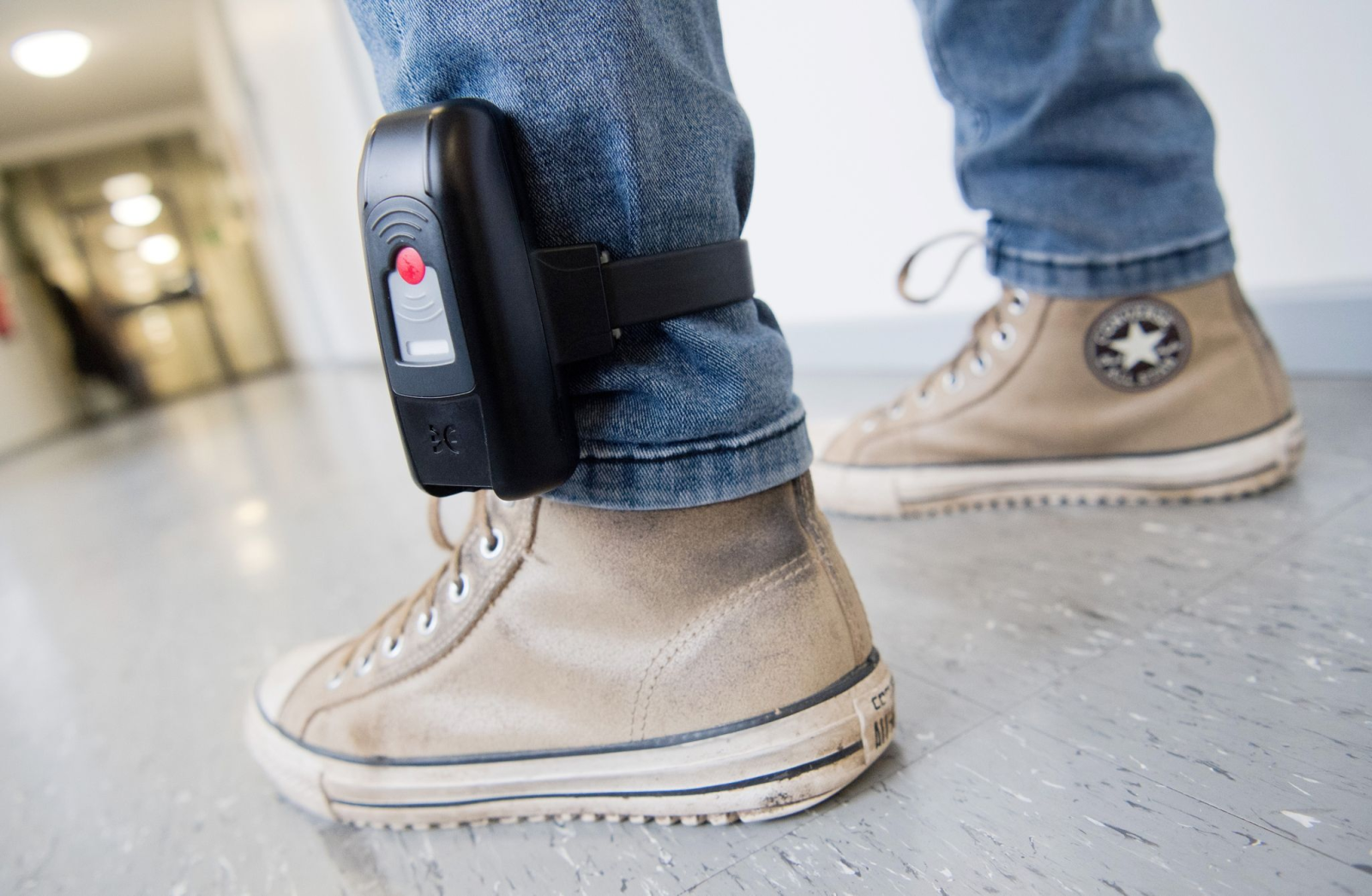 Ein Mann trägt eine elektronische Fußfessel.
