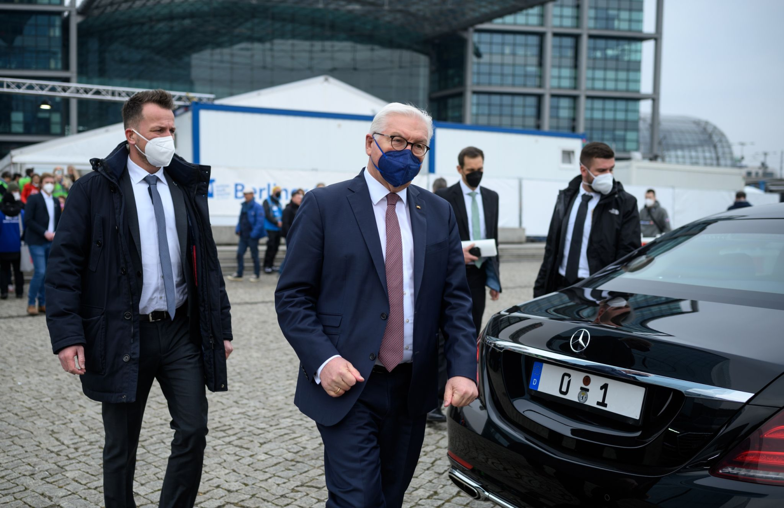 Bundespräsident Frank-Walter Steinmeier geht von Personenschützern begleitet zu seiner Limousine.