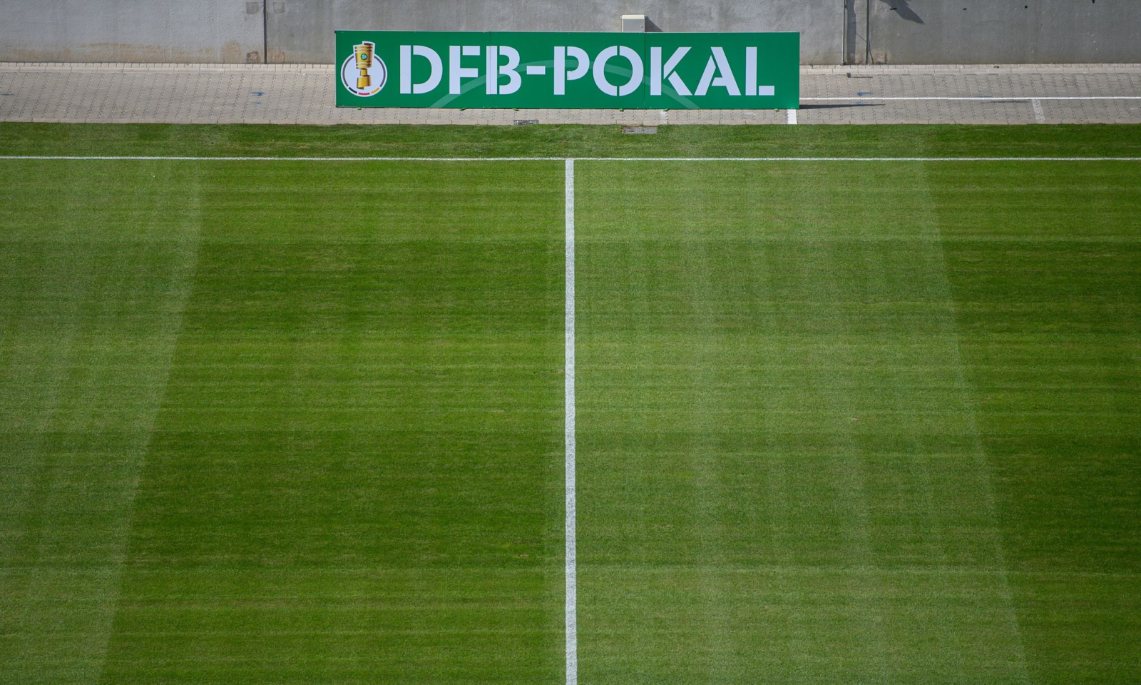 Eine Bande mit der Aufschrift DFB-Pokal steht am Spielfeld.