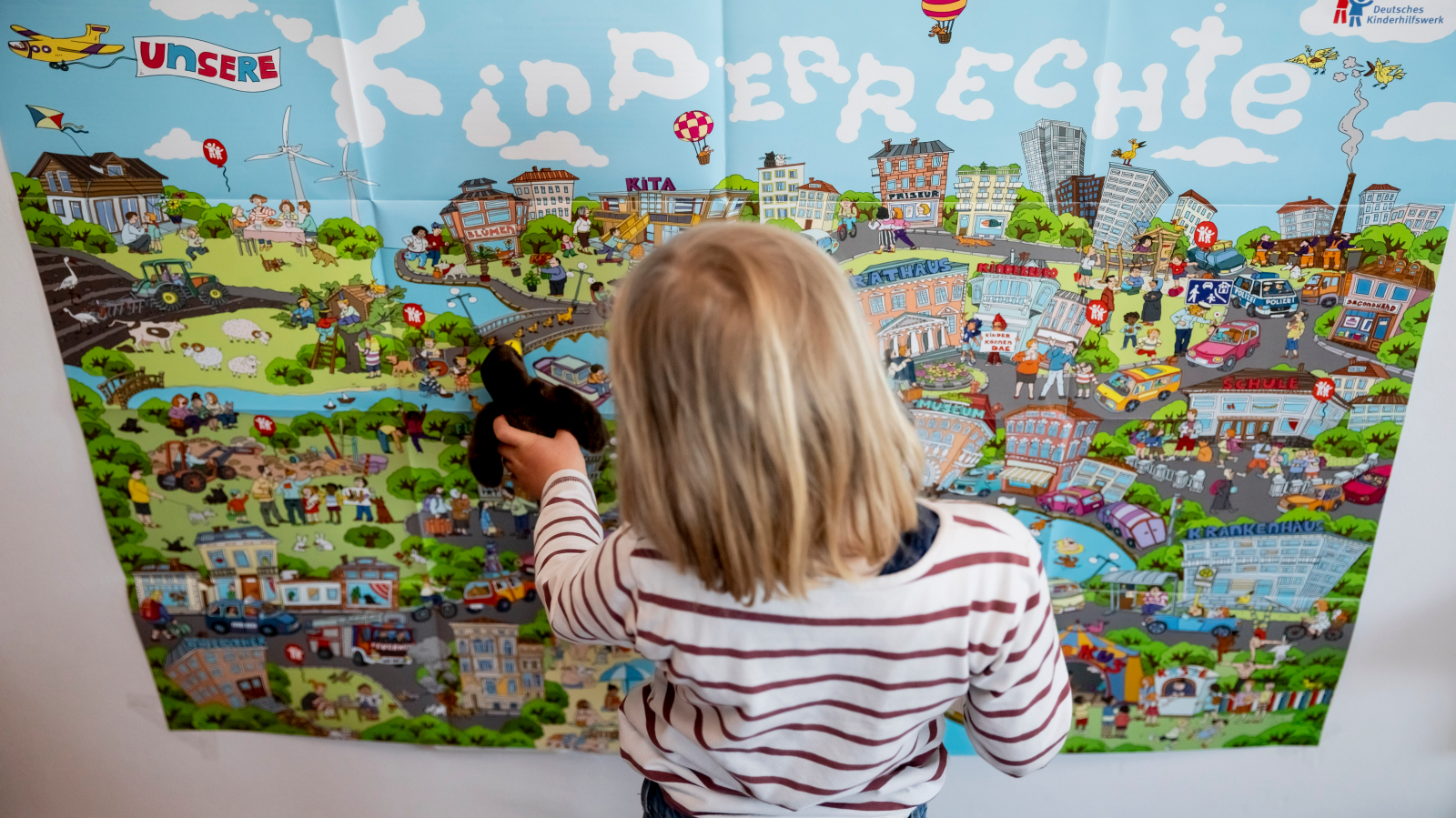 Symbol Foto: Berlin: Ein Kind steht vor einem Plakat des Deutschen Kinderhilfswerks mit der Aufschrift «Kinderrechte».(Symbolbild) (zu dpa: «Kinderschutzbund beklagt «Krise der Kindheit»») Foto: Christoph Soeder/dpa, © dpa