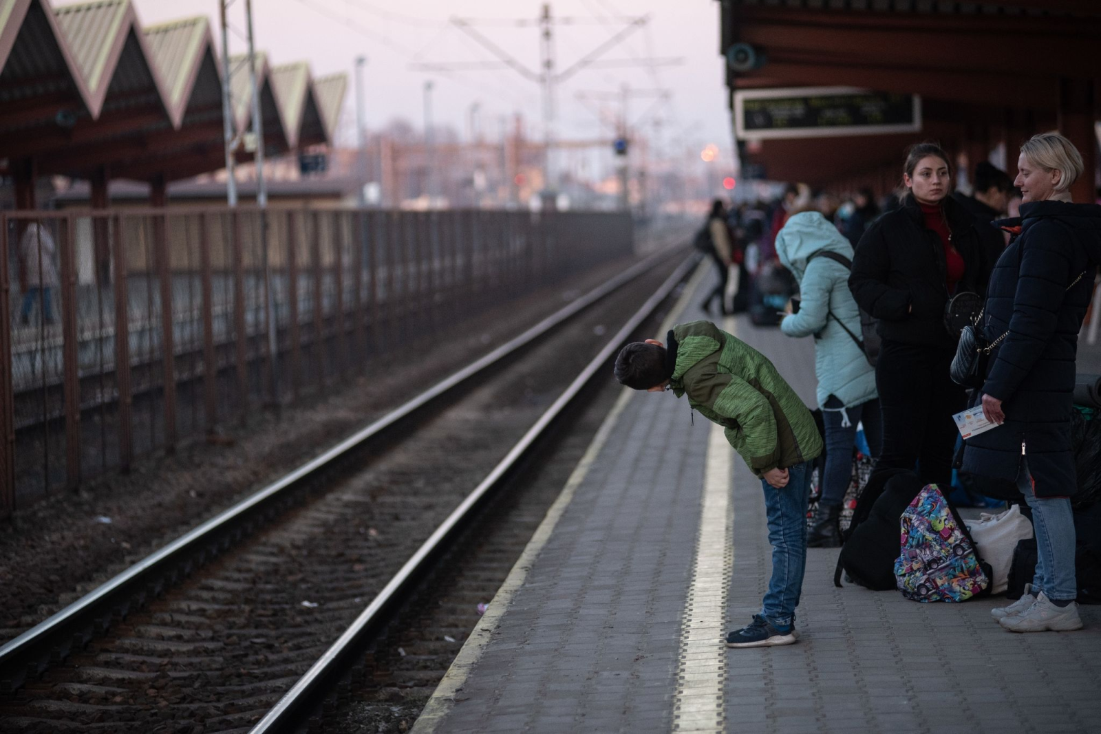 Ukrainische Flüchtlinge warten an einem Bahnhof auf einen Zug.
