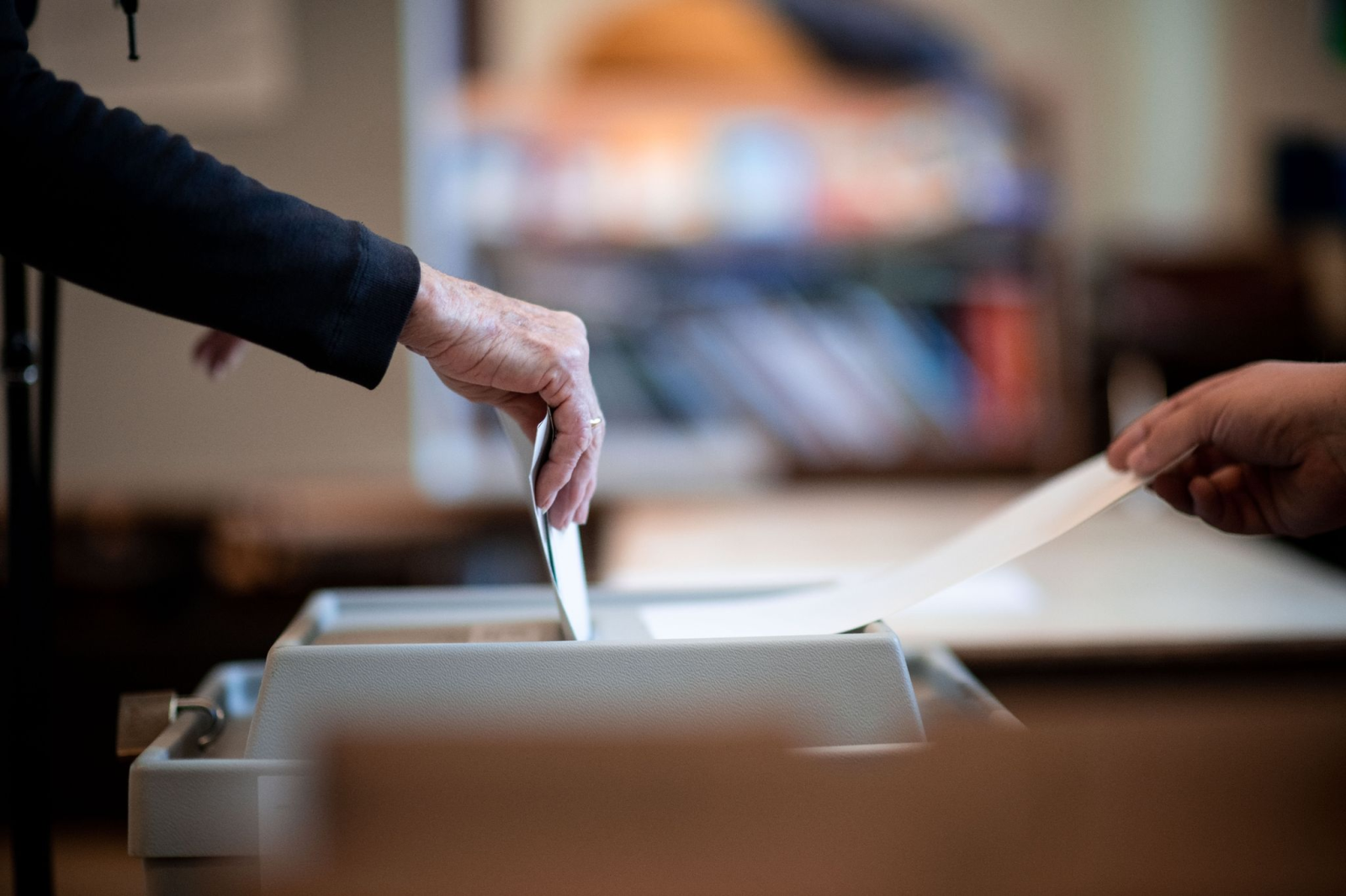 Eine Frau wirft ihren Stimmzettel in ein Wahlurne in einem Wahllokal.