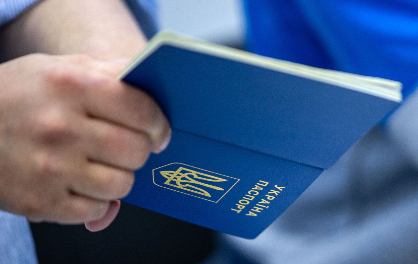 Ein Mann hält einen ukrainischen Reisepass in der Hand.