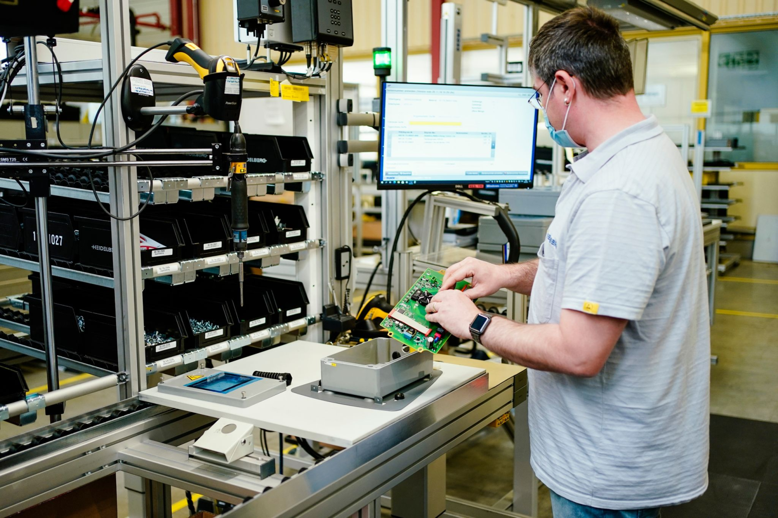 Ein Mitarbeiter montiert im Stammwerk eines Maschinenbauers ein Ladegerät.