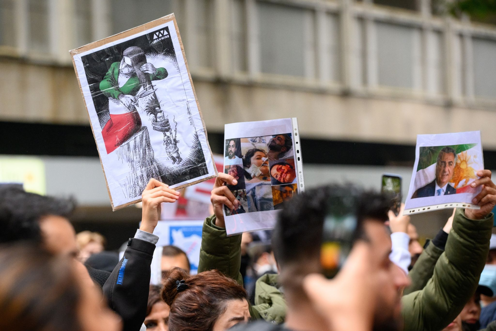 Menschen halten Fahnen und Schilder auf einer Solidaritätskundgebung nach dem Tod von Iranerin Mahsa Amini.