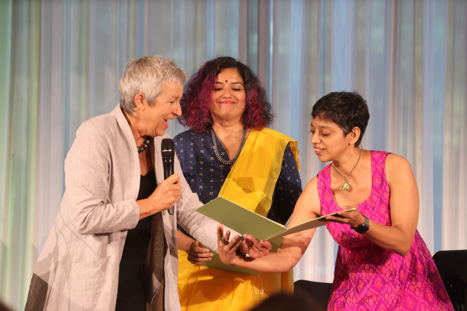 Carola Lentz (l), Präsidentin des Goethe-Institutes, verleiht an Nimi Ravindran und Shiva Pathak die Medaille.