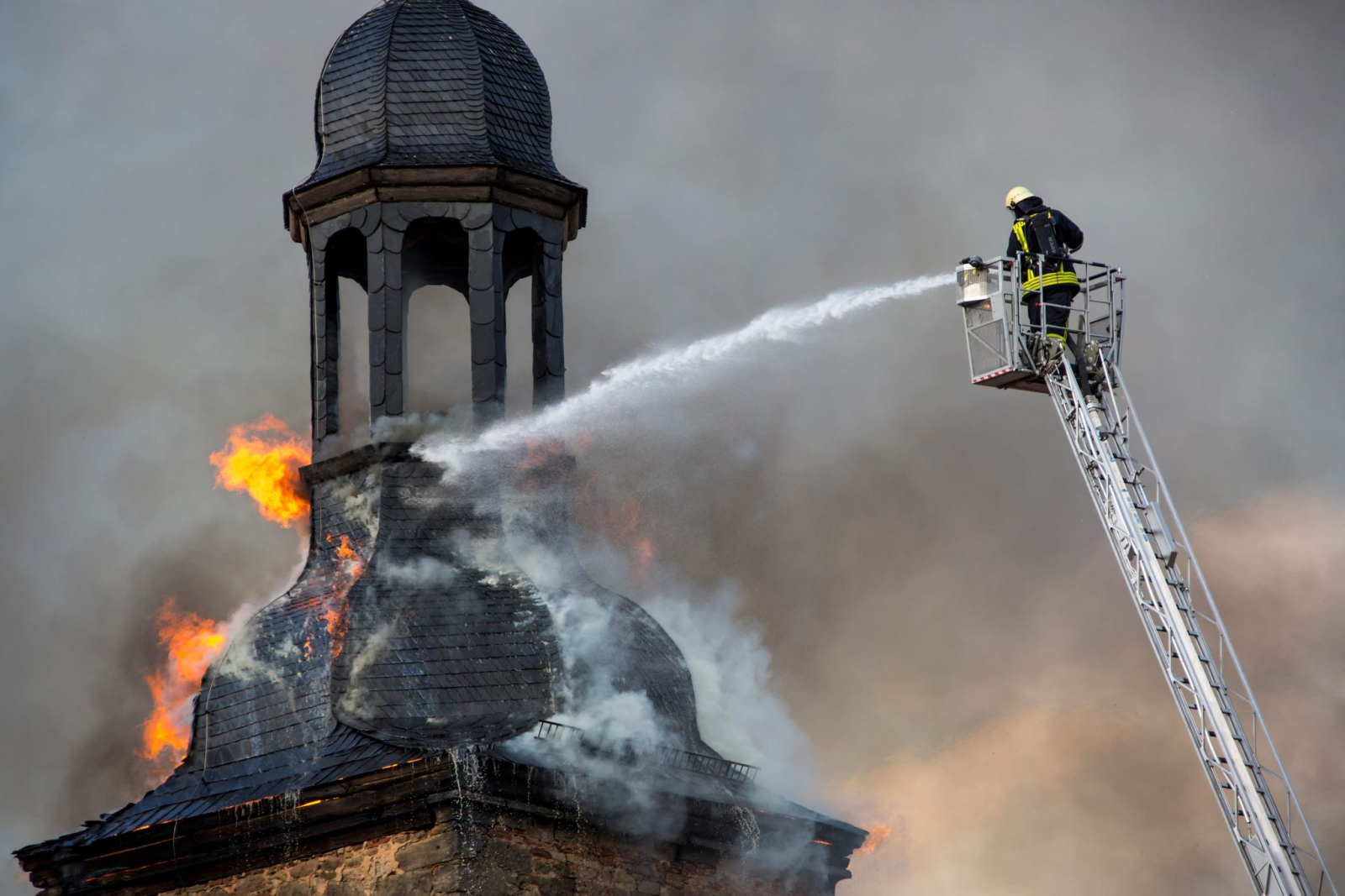 Ein Feuerwehrmann versucht 2012 einen Brand an der Kirche in Walldorf unter Kontrolle zu bringen.