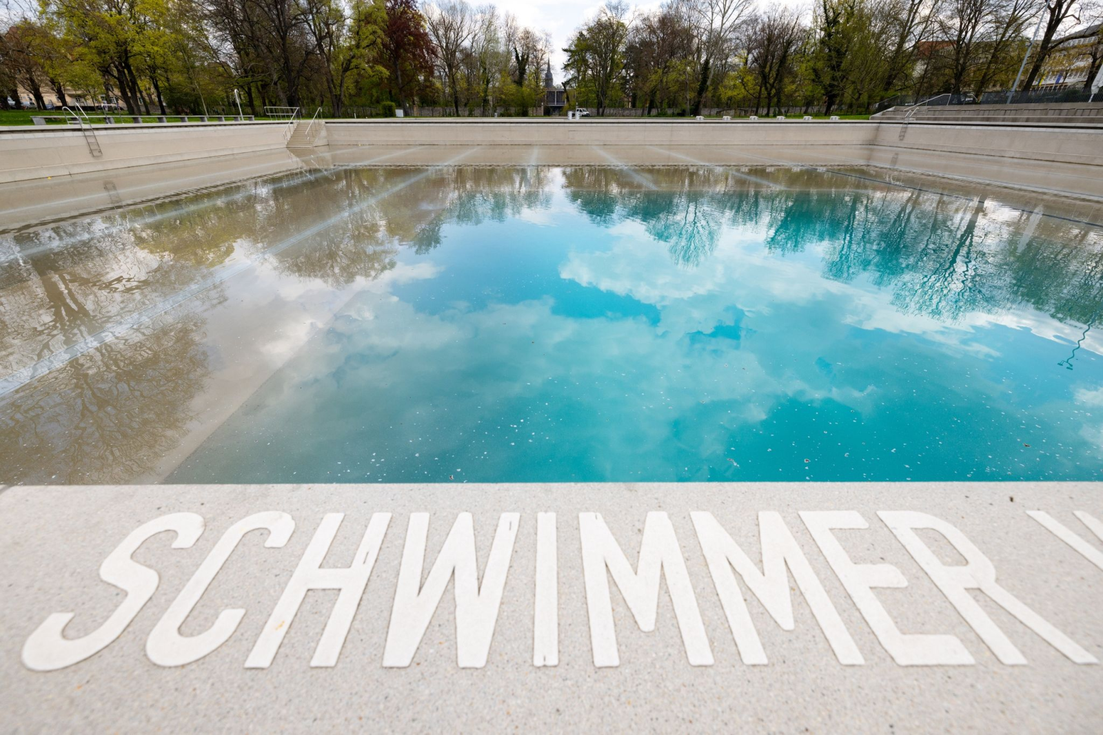 „Schwimmer“ steht am Becken des Schwanseebad, während das Wasser eingelassen wird.