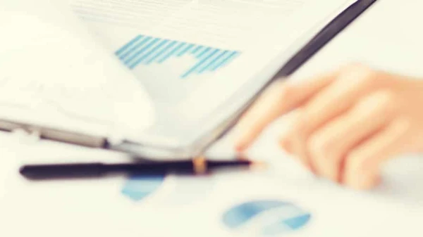 Hand auf einem Tisch mit vielen Grafiken, © Shutterstock Hand auf einem Tisch mit vielen Grafiken, © Shutterstock