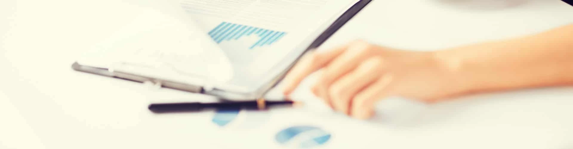 Hand auf einem Tisch mit vielen Grafiken, © Shutterstock Hand auf einem Tisch mit vielen Grafiken, © Shutterstock