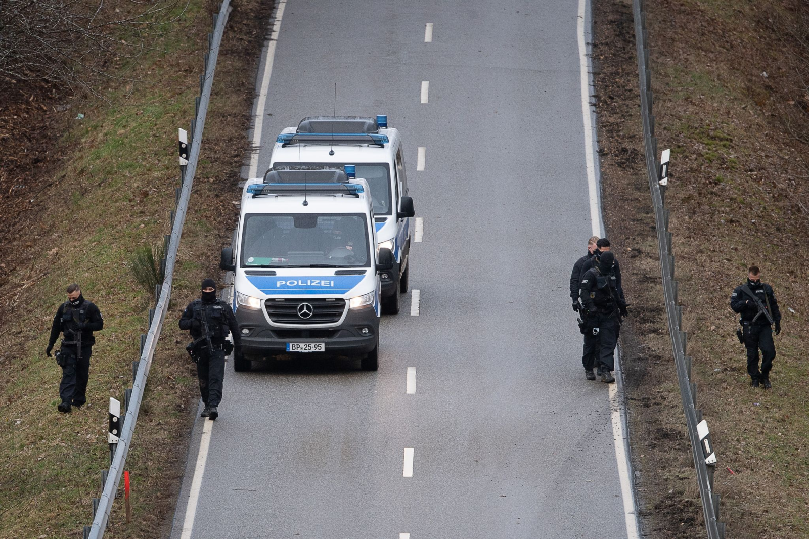 Polizisten suchen eine Straße in der Nähe des Tatorts ab.