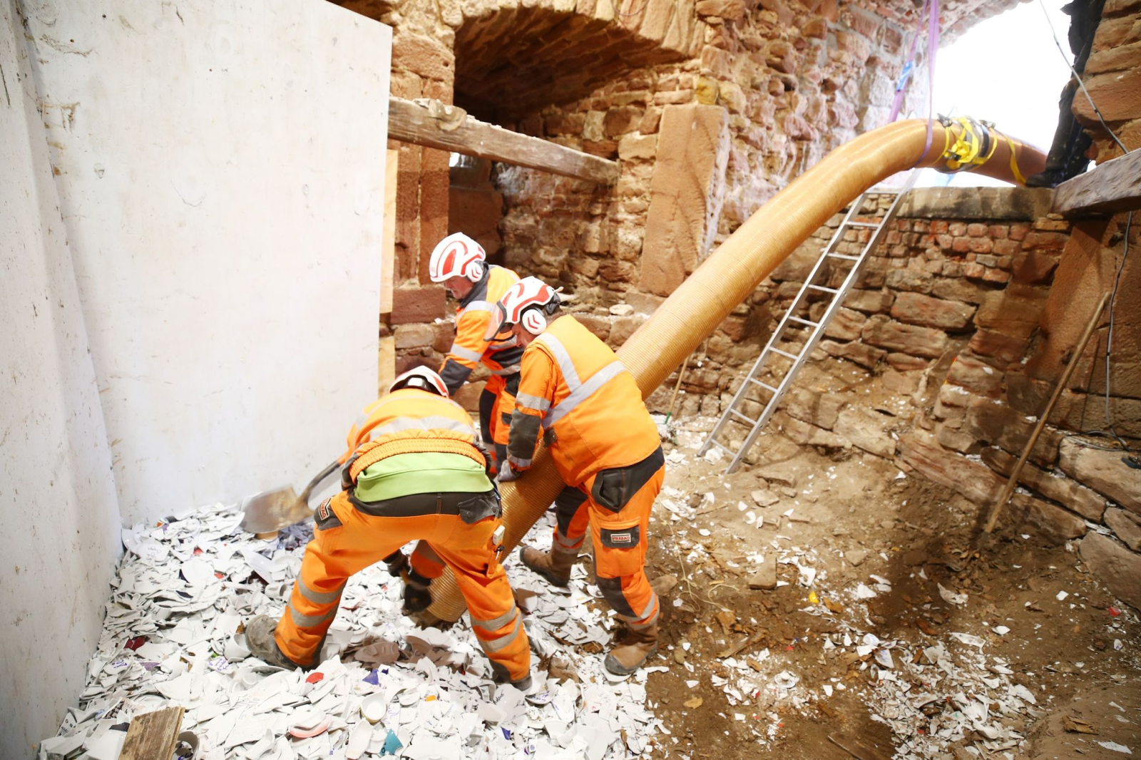 Arbeiter saugen mit einem Schlauch die letzten Reste Porzellan aus dem letzten Verteidigungsturm der Leuchtenburg.