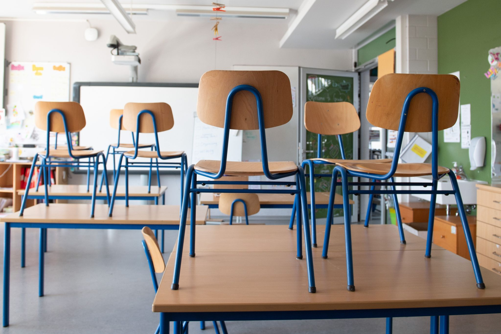 Stühle stehen in einem Klassenzimmer auf den Tischen.