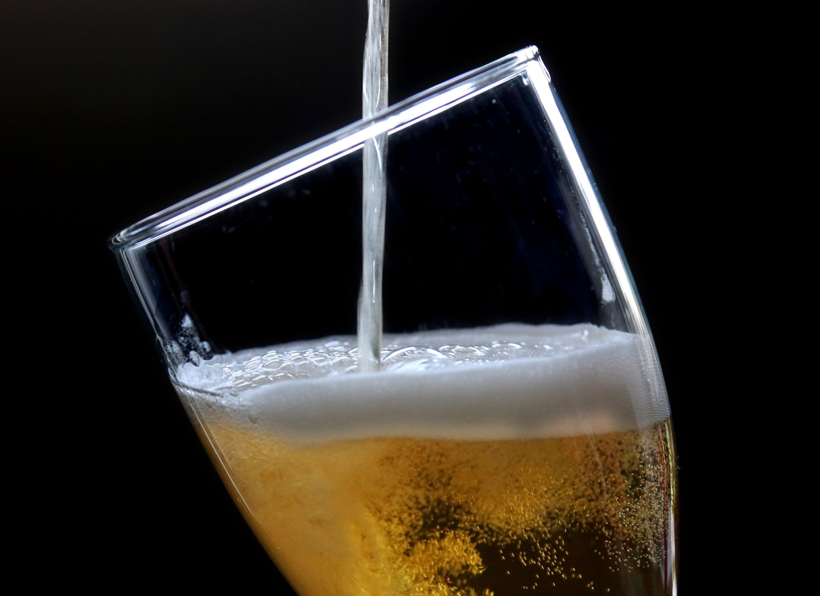 Ein Bier wird in ein Glas gezapft.