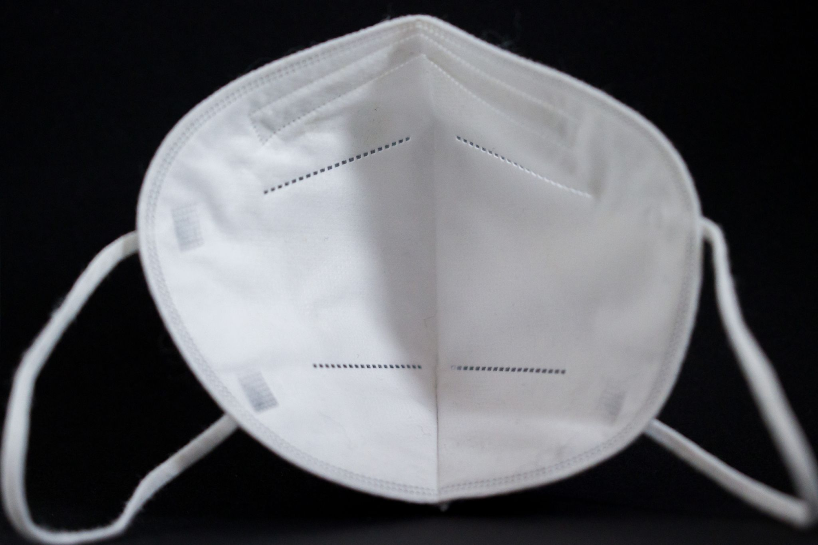 Eine FFP2-Maske liegt auf einem Tisch., © Daniel Karmann/dpa/Symbolbild