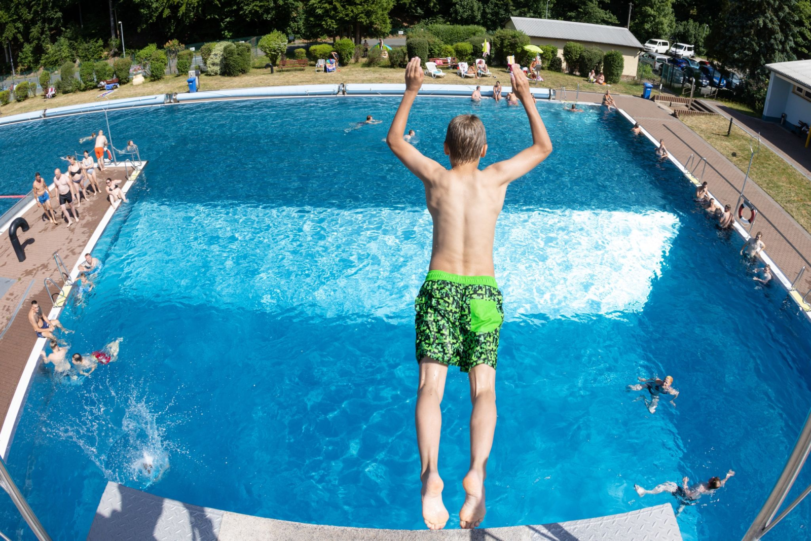 Ein Junge springt vom 5-Meter-Turm im Sport- und Freizeitbad Hammergrund ins Wasser.