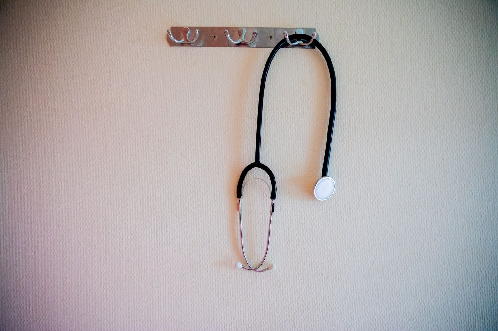 Ein Stethoskop hängt an einer Garderobe.