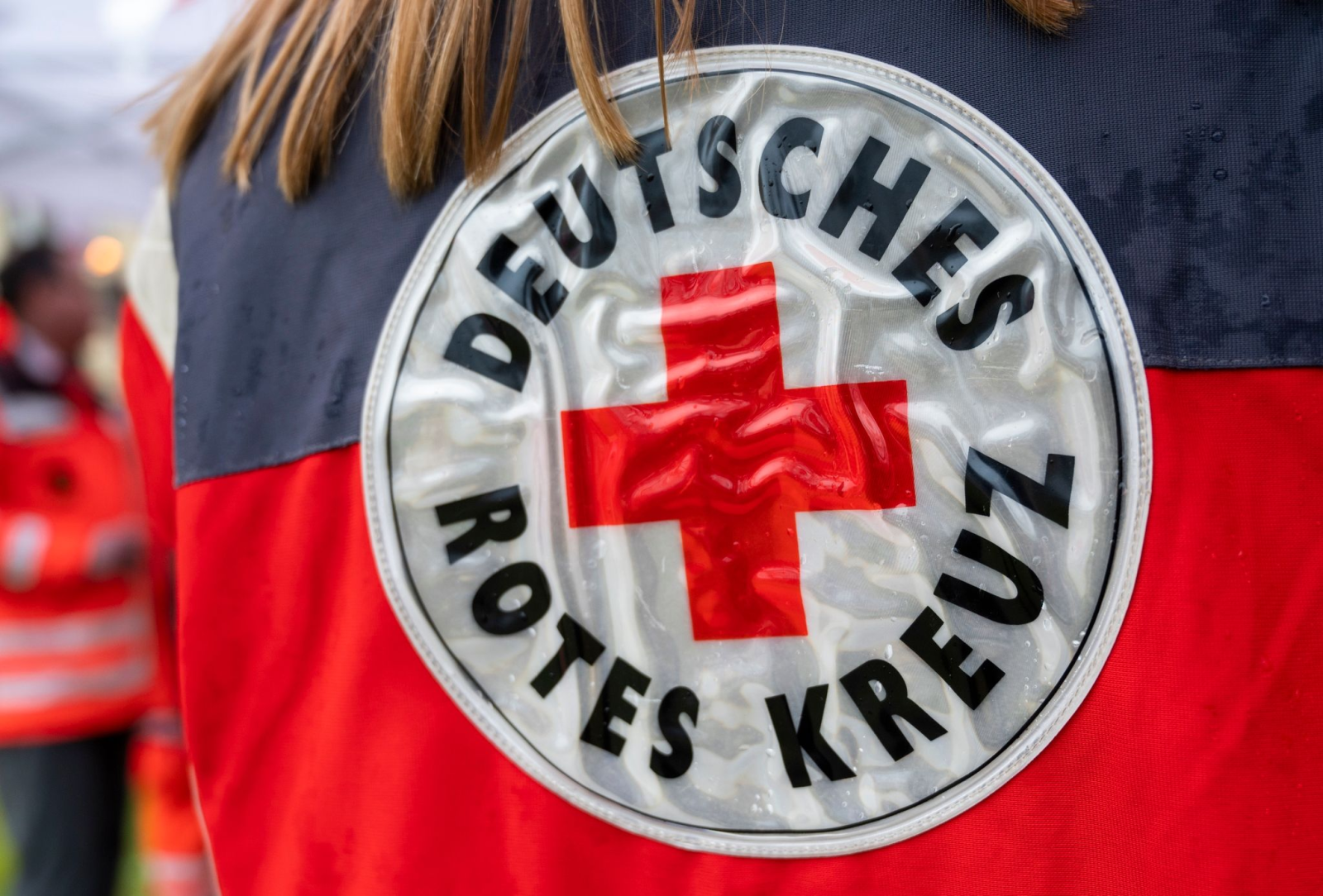 Eine Mitarbeiterin des Deutschen Roten Kreuz trägt eine Jacke mit dem Logo vom DRK.