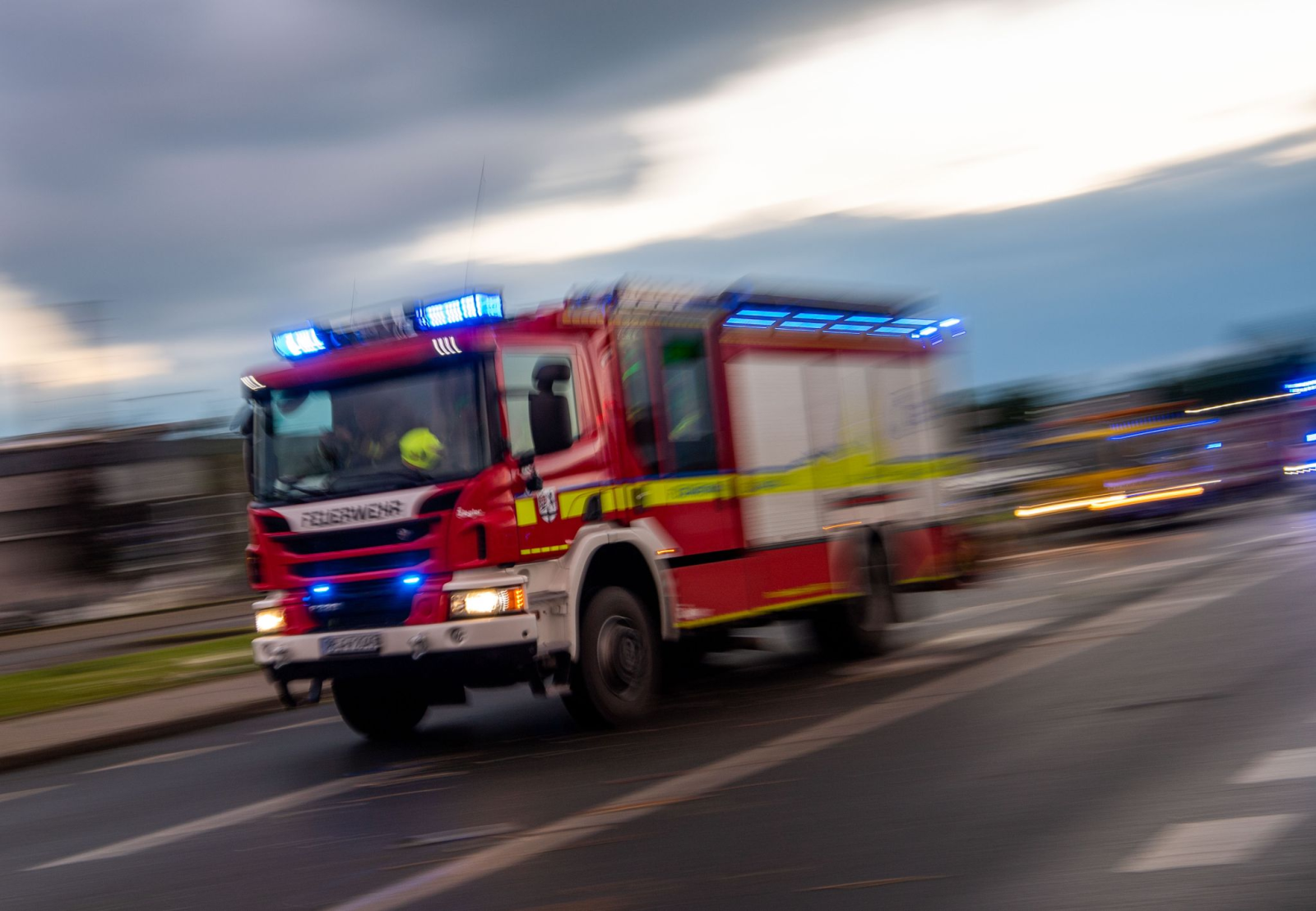Ein Löschfahrzeug der Feuerwehr fährt mit Blaulicht zu einem Einsatz., © Lino Mirgeler/dpa/Symbolbild