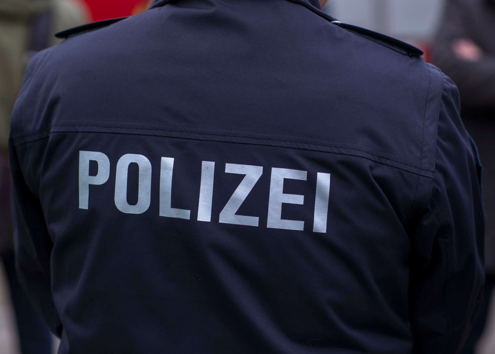 «Polizei» steht auf der Uniform eines Polizisten.