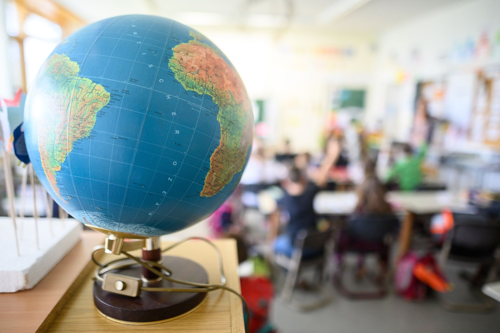Ein Globus steht in einem Klassenraum.
