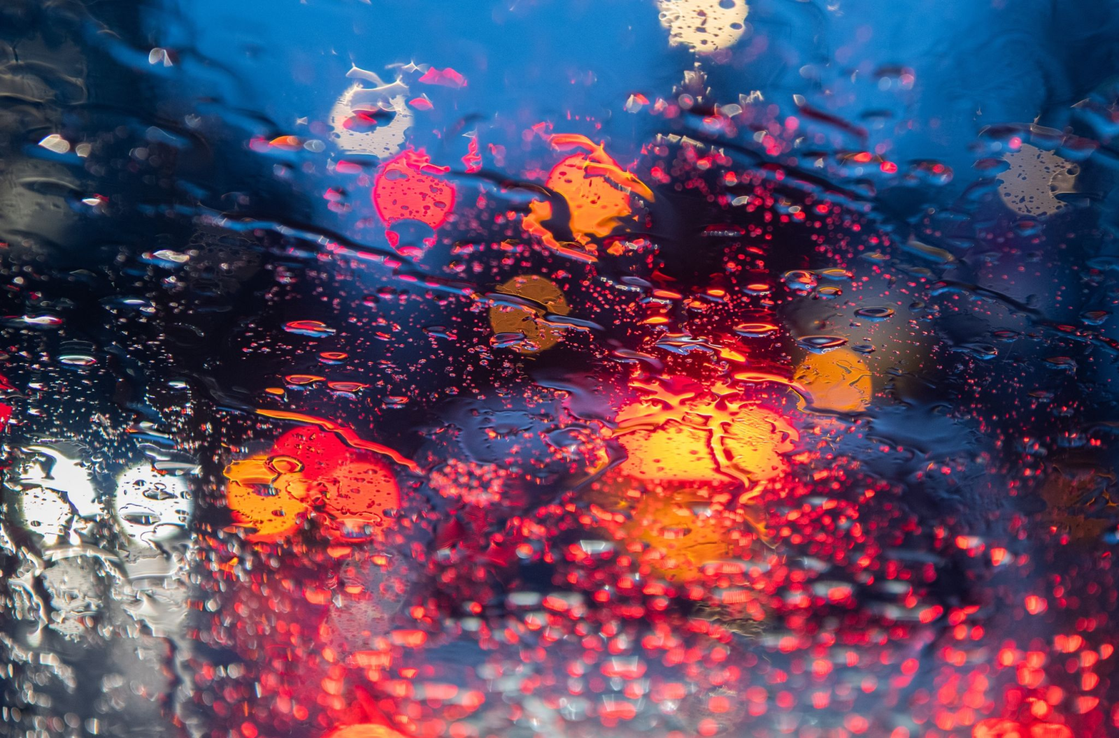 Regentropfen sind auf einer Autoscheibe zu sehen.