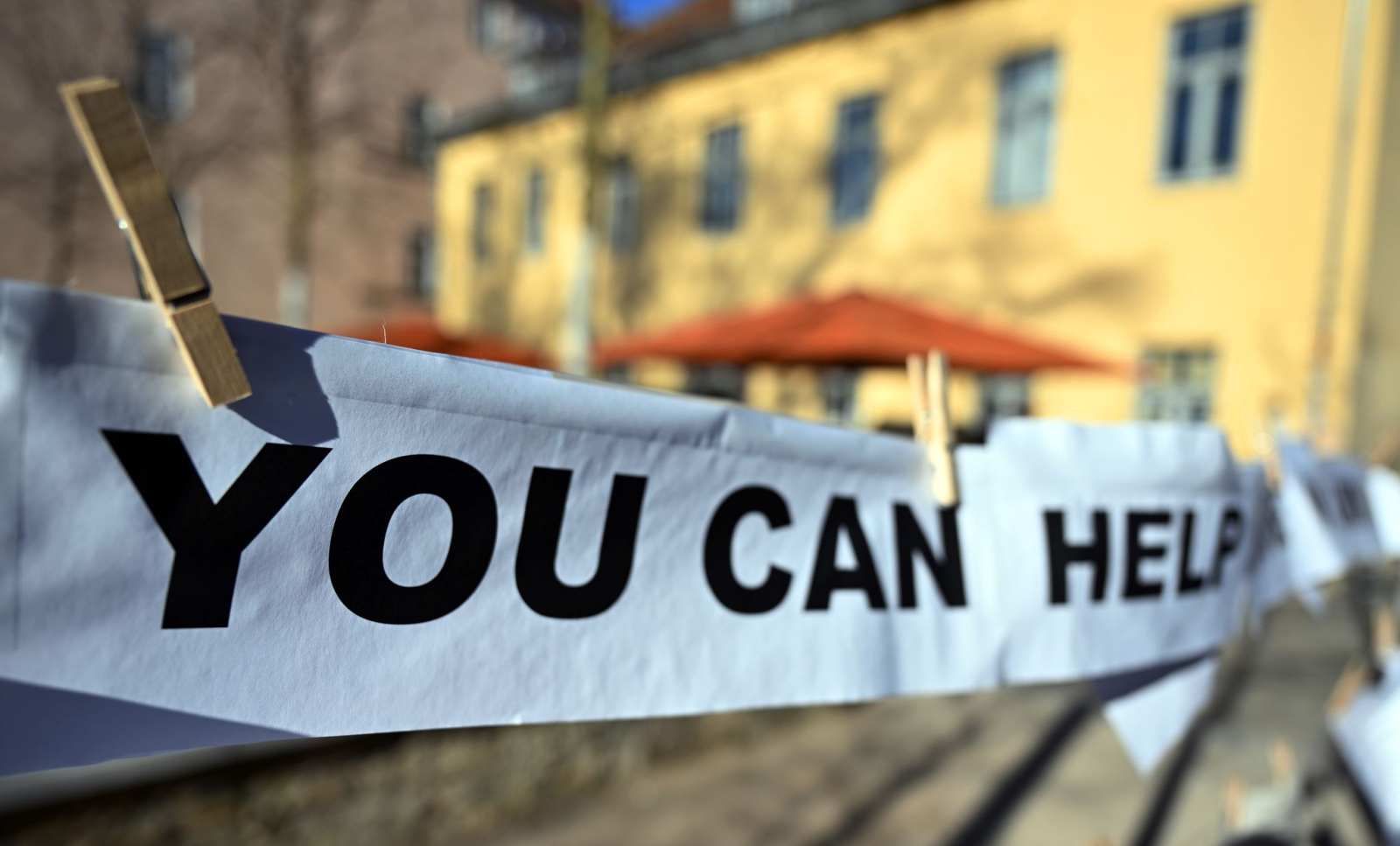 "You can help" steht auf dem Zettel, der vor der Bauhaus-Universität Weimar hängt.