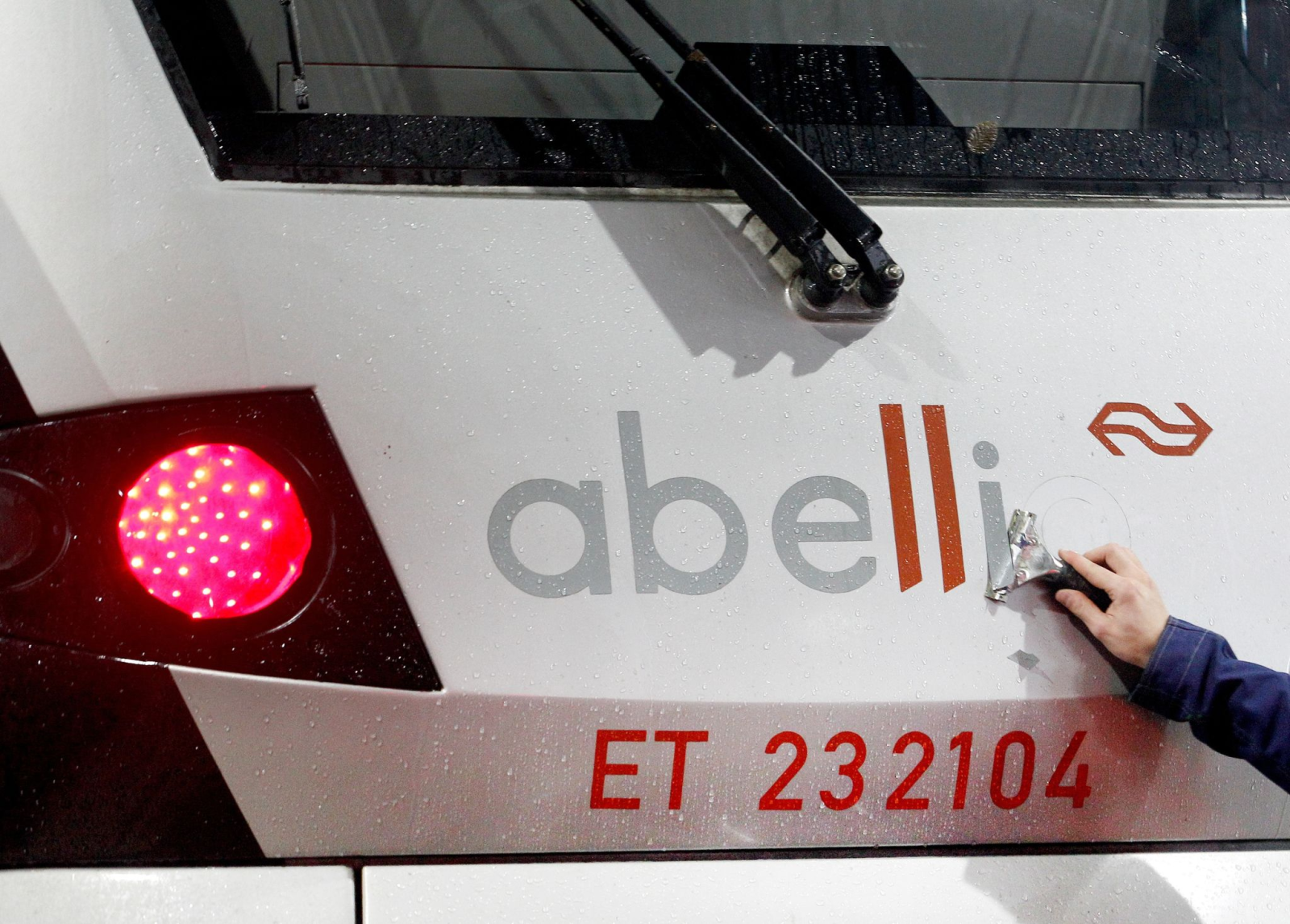 Ein Mitarbeiter der DB-Regio entfernt den Schriftzug «Abellio» von einem Nahverkehrszug.