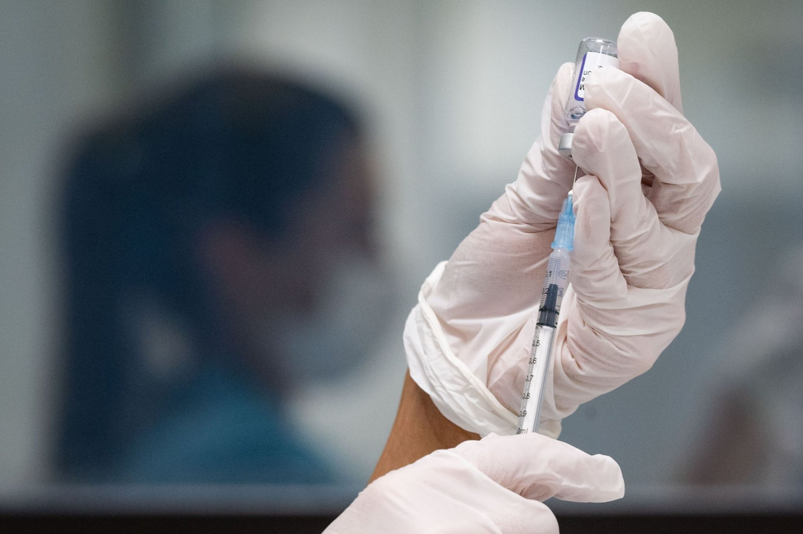 Eine Werksärztliche Assistentin zieht in einem Impfzentrum eine Spritze mit Corona-Impfstoffs auf.