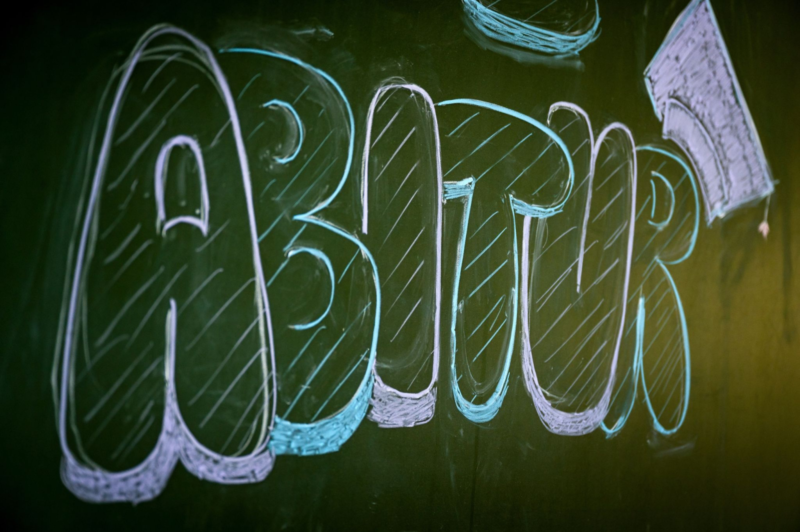 «Abitur» steht auf einer Tafel im Klassenzimmer eines Gymnasiums., © Sina Schuldt/dpa/Symbolbild